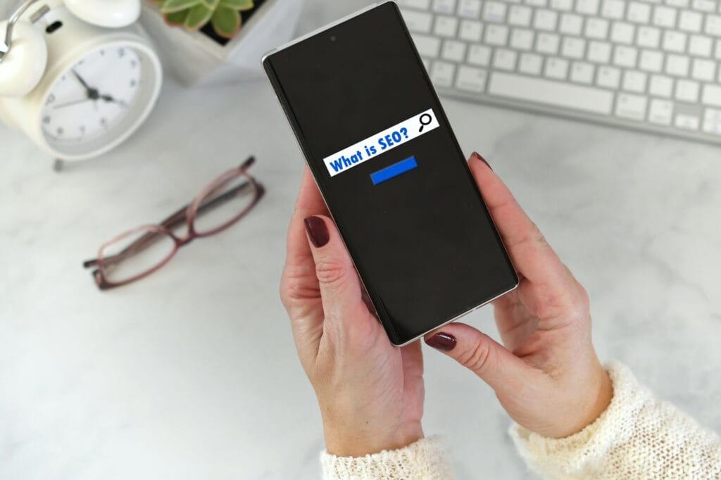 Frau hält Telefon mit Suchbildschirm - was ist SEO-Suchmaschinenoptimierung